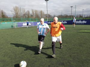 Two Walking Footballers compete for the ball